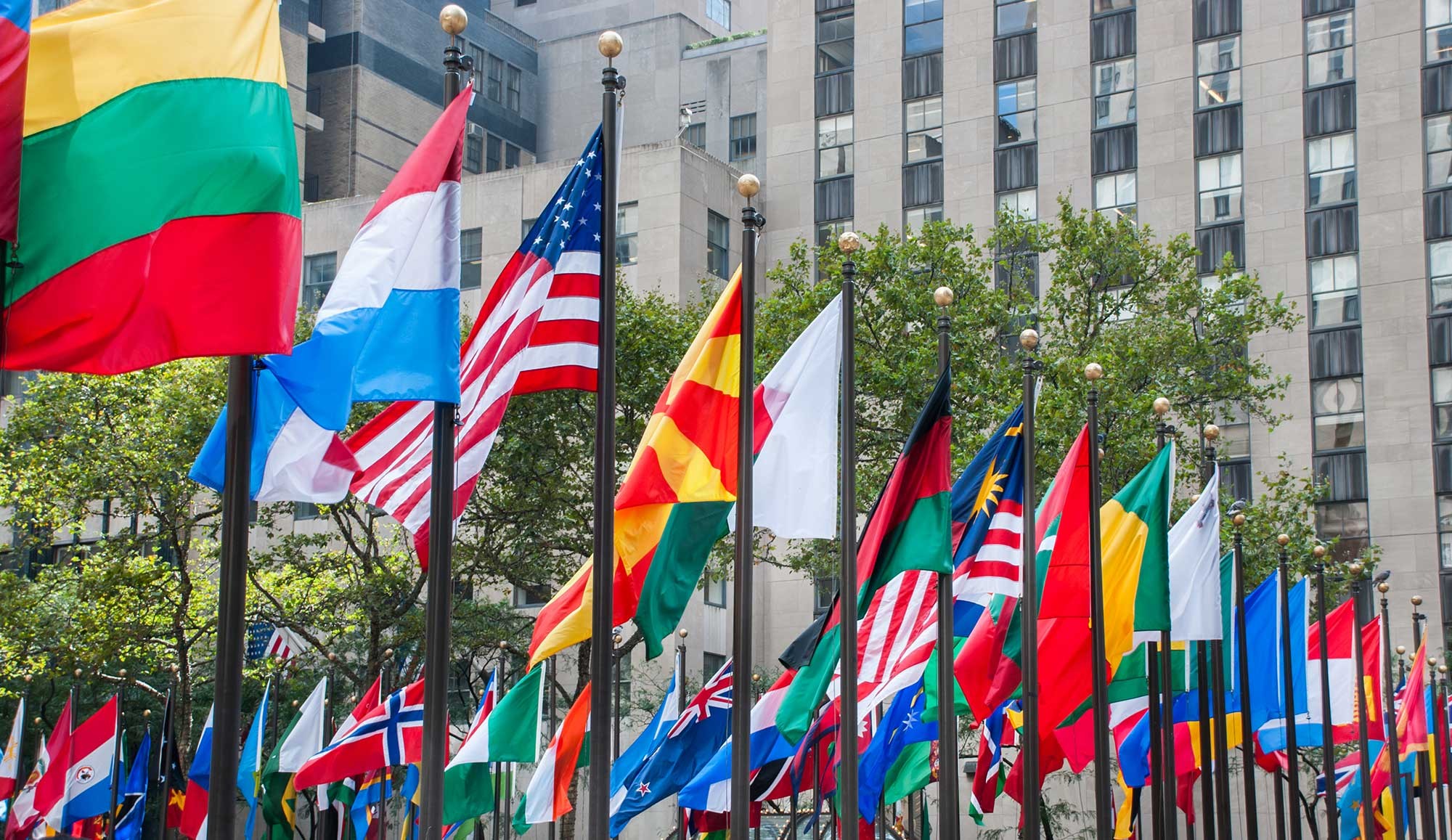 colorful flags lined up outside the United Nations building